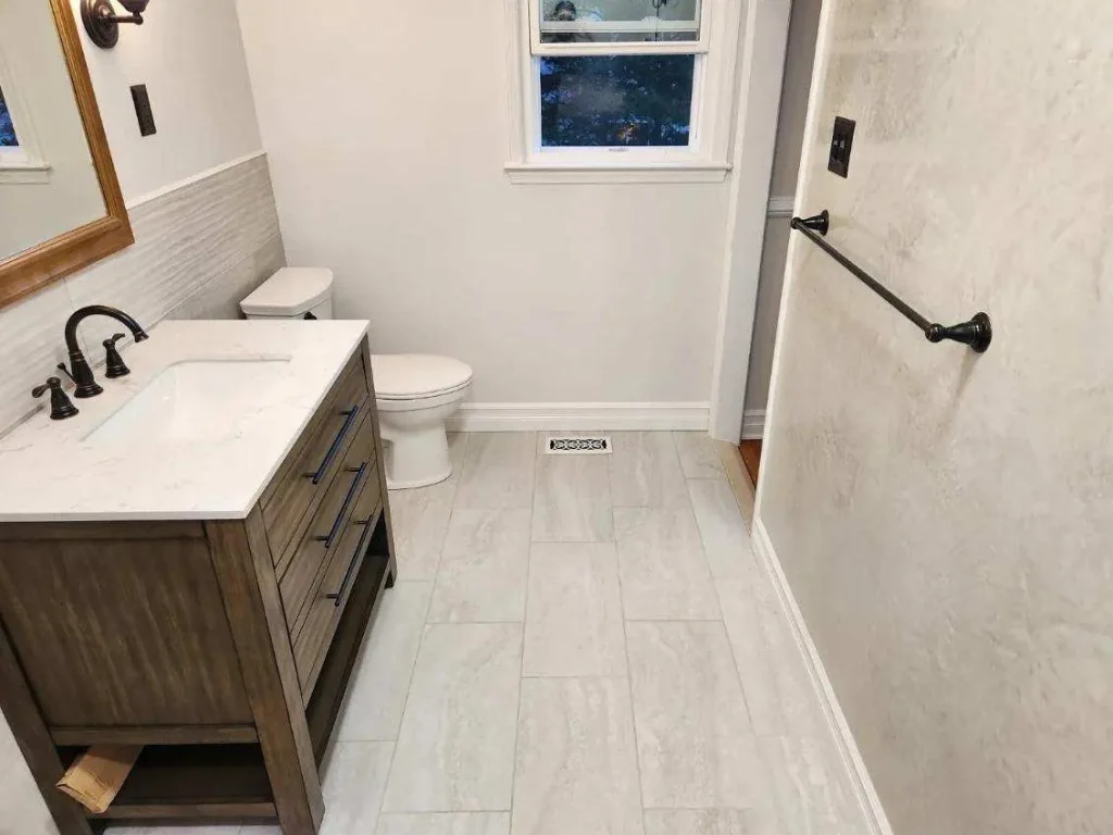 Bathroom with large-format floor tile and a wood vanity