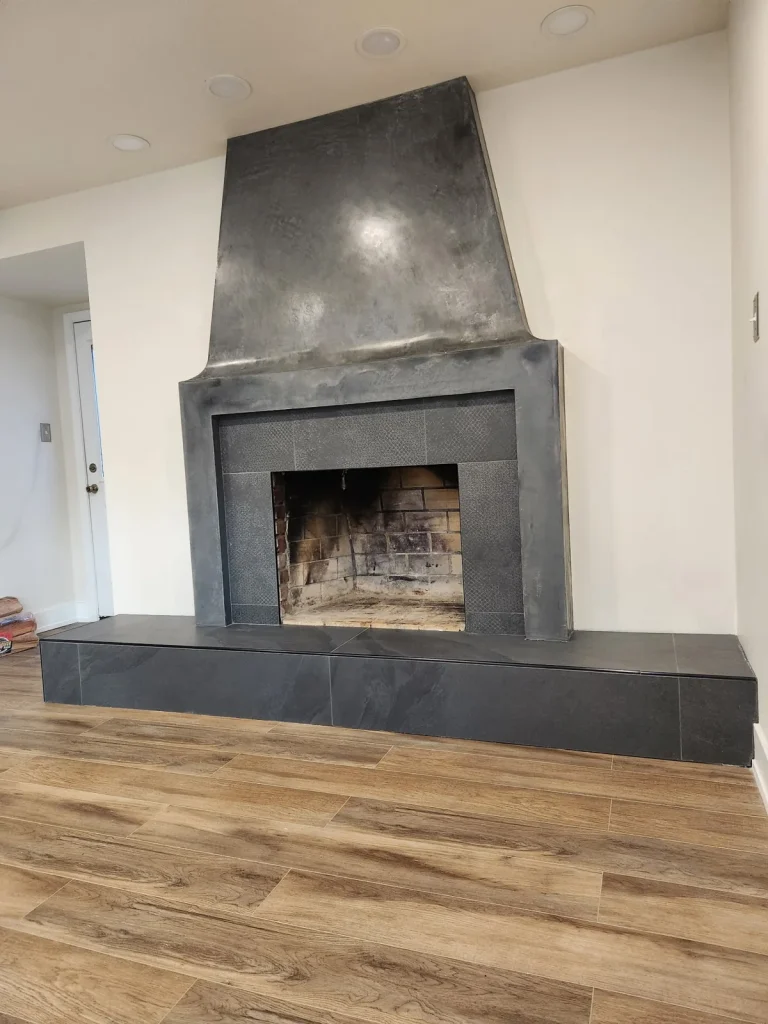 Dark decorative fireplace surround with a raised hearth