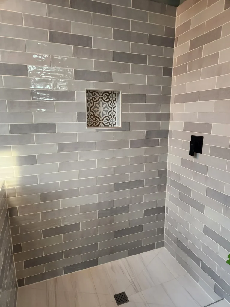 Gray rectangular shower tile with a decorative recessed niche