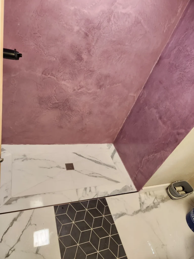 Rose-colored decorative wall finish with marble-look and dark floor tile