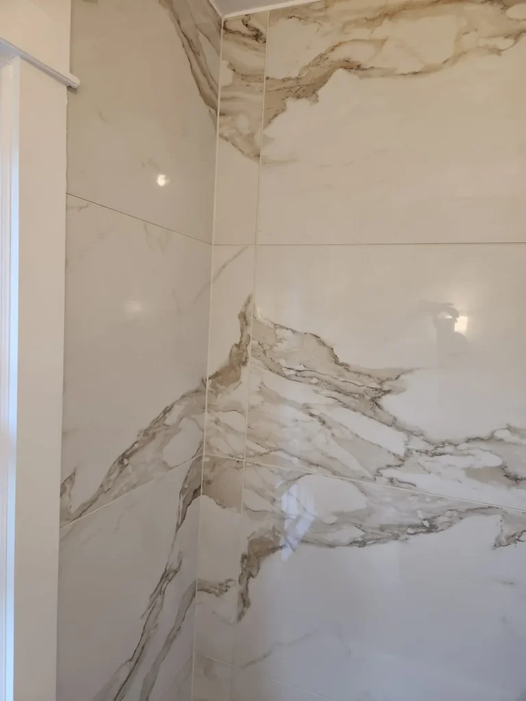 Close-up of marble-look shower tile and a recessed niche